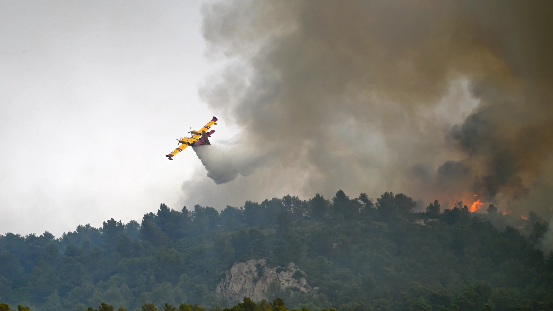 Saint-Laurent-de-la-Cabrerisse (France), 06/08/2025.- A firefighting airplane drops water on a forest fire near Saint Laurent de la Cabrerisse in Aude, France, 06 August 2025. Some 16,000 hectares have been burned so far and at least one person died in the wildfire in sourthern France. (incendio forestal, Francia) EFE/EPA/Philippe Magoni