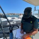 Un agente de la Guardia Civil levanta un acta por fondeo ilegal en Formentera.