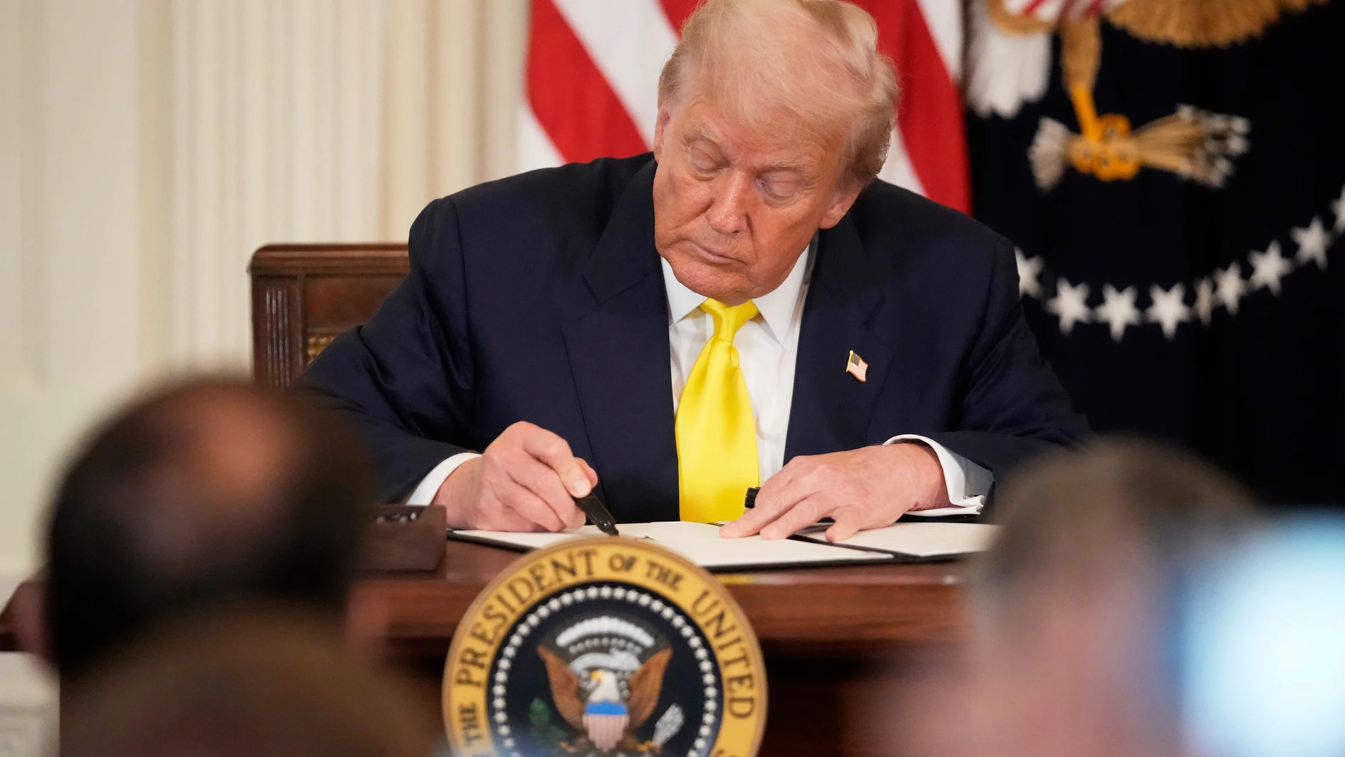 President Donald Trump signs a proclamation declaring National Purple Heart Day in the East Room of the White House, Thursday, Aug. 7, 2025, in Washington. (AP Photo/Mark Schiefelbein)