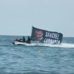 La lona de Hazte Oír de "Sánchez, corrupto" en el mar, después de que fuesen retirada por un juez del Congreso de los Diputados