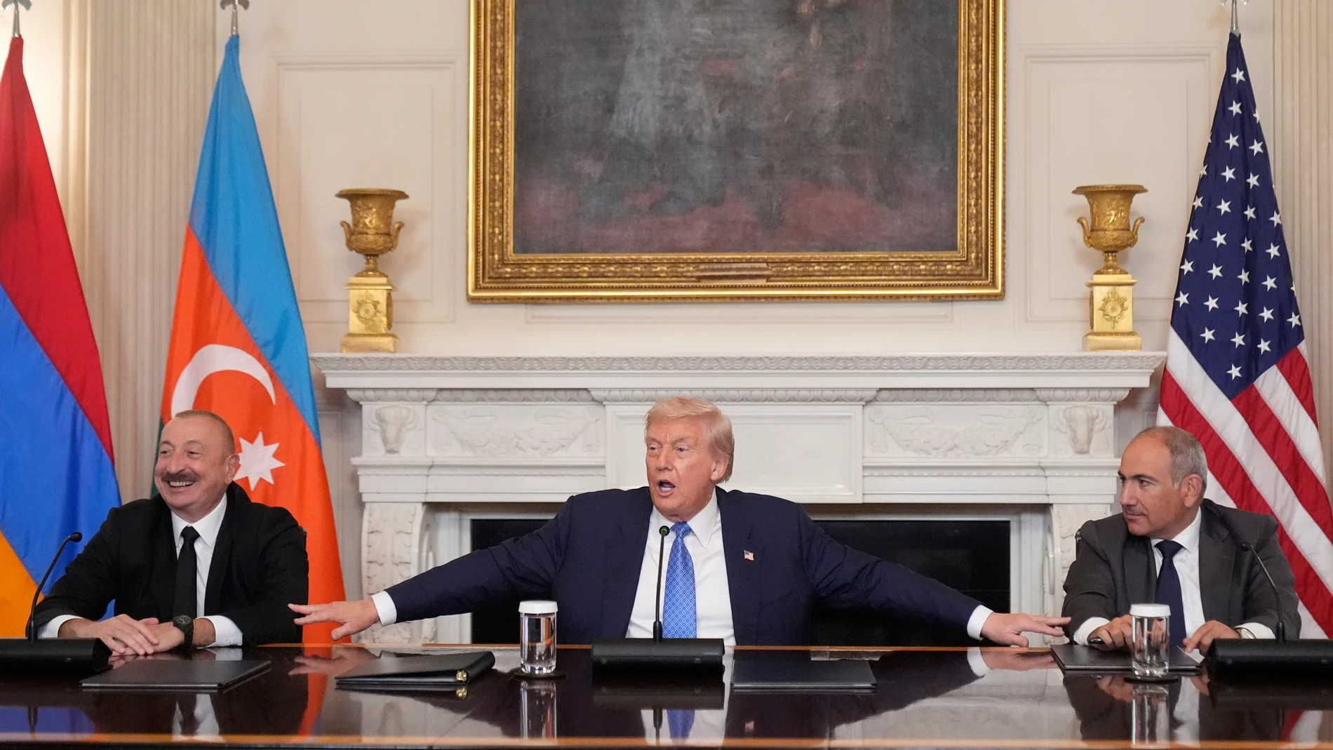 President Donald Trump, center, joined by Armenian Prime Minister Nikol Pashinyan, right, and Azerbaijan President Ilham Aliyev, speaks during a trilateral signing ceremony in the State Dining Room of the White House, Friday, Aug. 8, 2025, in Washington. (AP Photo/Mark Schiefelbein)