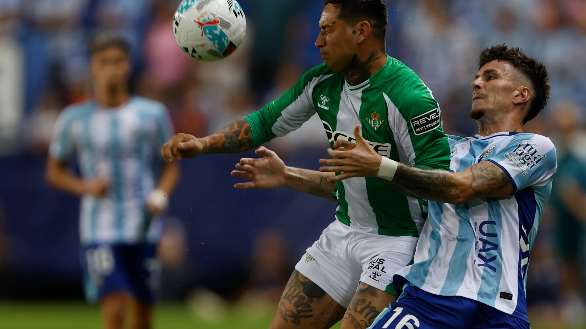 MÁLAGA, 09/08/2025.- El delantero del Betis Chimy Ávila (i) lucha con Murillo, del Málaga, durante el partido del Torneo Costa del Sol que Málaga CF y Real Betis disputan hoy sábado en el estadio de La Rosaleda. EFE/Jorge Zapata