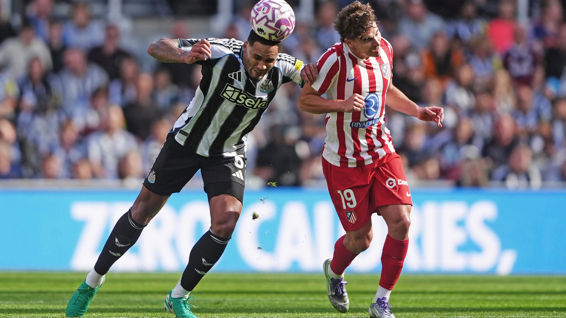 Newcastle United's Jamaal Lascelles, left, and Atletico Madrid's Julian Alvarez in action during the Sela Cup soccer match between Newcastle United and Atletico Madrid at St. James' Park, Newcastle, England, Saturday Aug. 9, 2025. (Owen Humphreys/PA via AP)