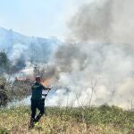 Un guardia civil intenta sofocar el fuego que afecta a uno de los municipios evacuados por el incendio originado en Yeres.