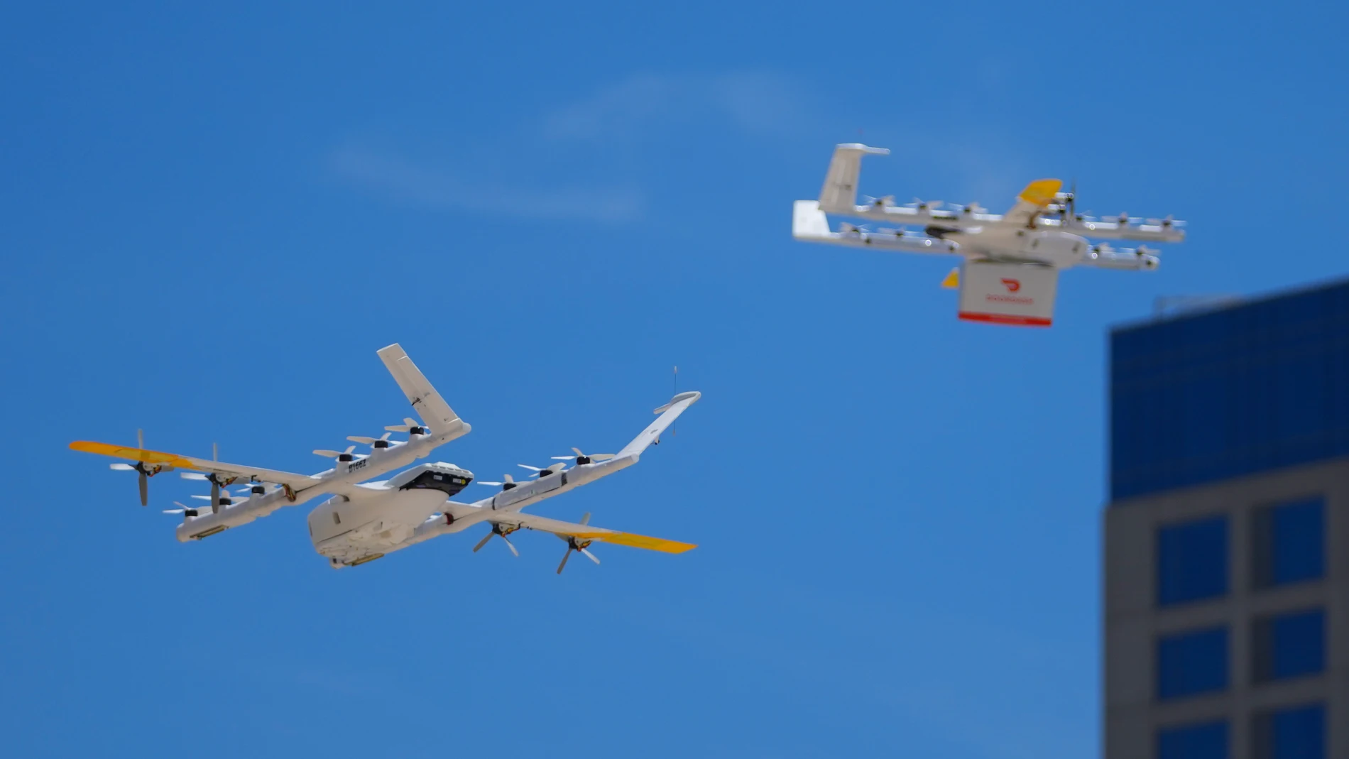 A drone, left, lands at a helipad as another lifts off with a DoorDash order, Thursday, July 31, 2025, in Frisco, Texas. (AP Photo/Julio Cortez)