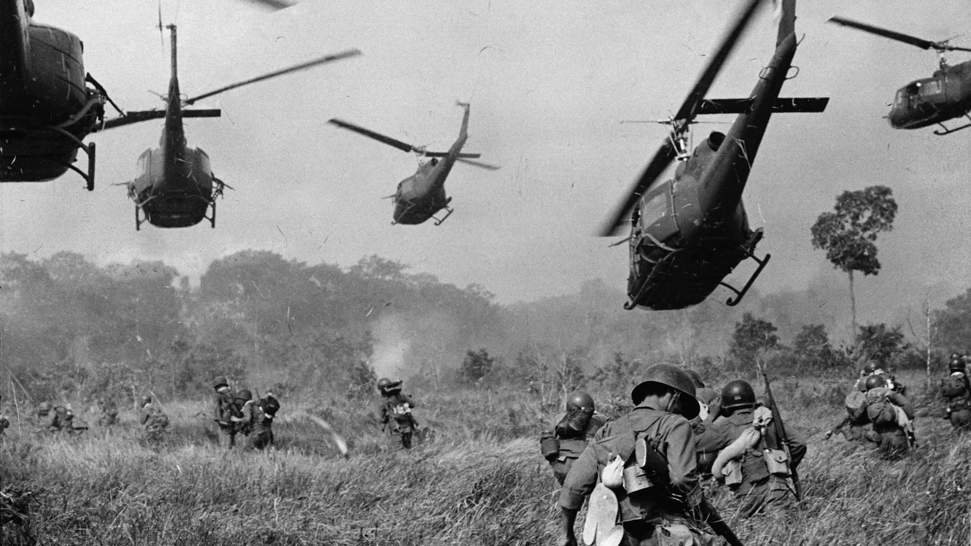 In this March 1965 file photo shot by Associated Press photographer Horst Faas, hovering U.S. Army helicopters pour machine gun fire into the tree line to cover the advance of South Vietnamese ground troops in an attack on a Viet Cong camp 18 miles north of Tay Ninh, Vietnam, northwest of Saigon near the Cambodian border.