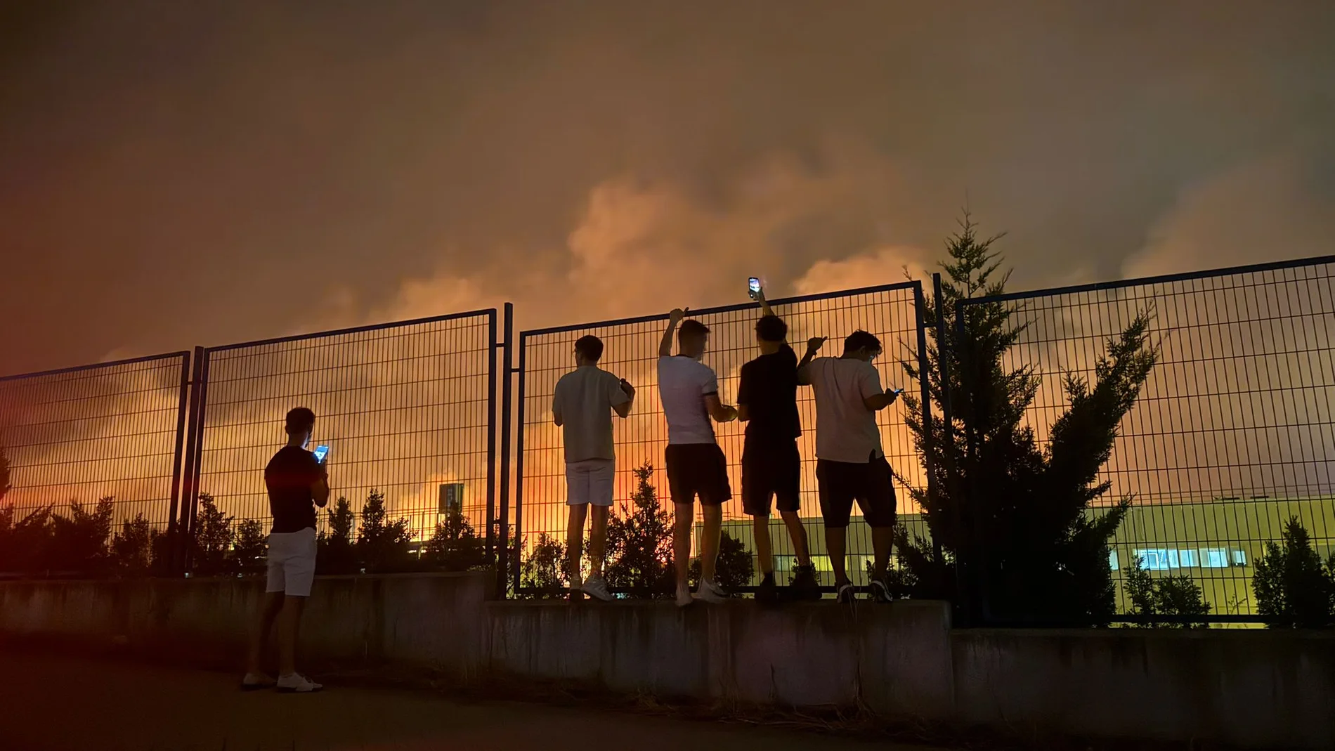 Unos vecinos observan la evolución del fuego
