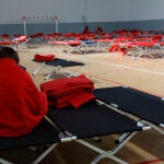 Una persona se arropa en la madrugada del lunes en el espacio Enrique Más, habilitado para desalojados tras el incendio de Tres Cantos del 11 de agosto.