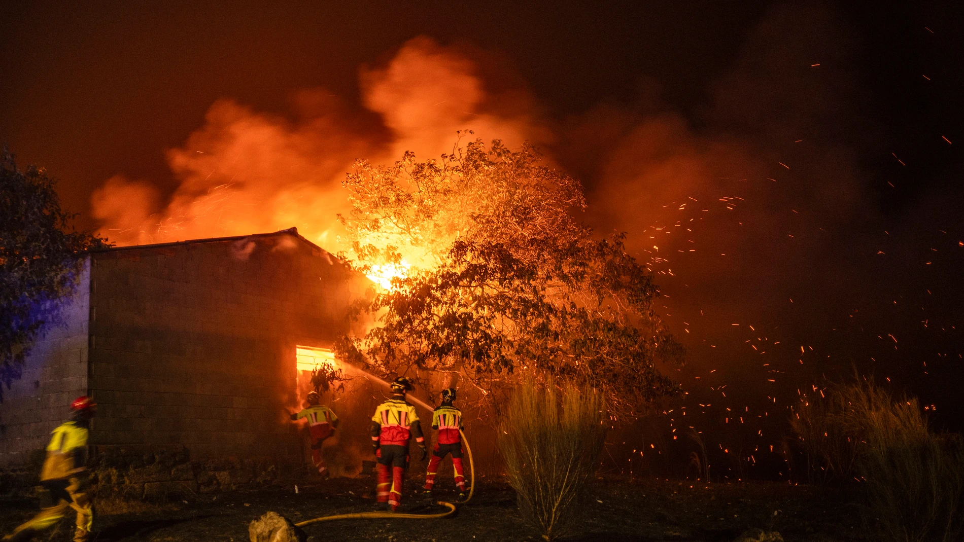 MONTERREI (OURENSE), 14/08/2025.-Los bomberos tratan de sofocar un incendio en una construcción en la localidad de A Caridade, en el municipio de Monterrei (Ourense). Zamora y Ourense atraviesan horas críticas con incendios forestales que avanzan sin control, que en conjunto podrían haber quemado ya más de 50.000 hectáreas que han dañado pueblos y que mantienen desalojados a miles de vecinos de medio centenar de localidades. También siguen ardiendo otras zonas de España, como Castilla-La Manc...