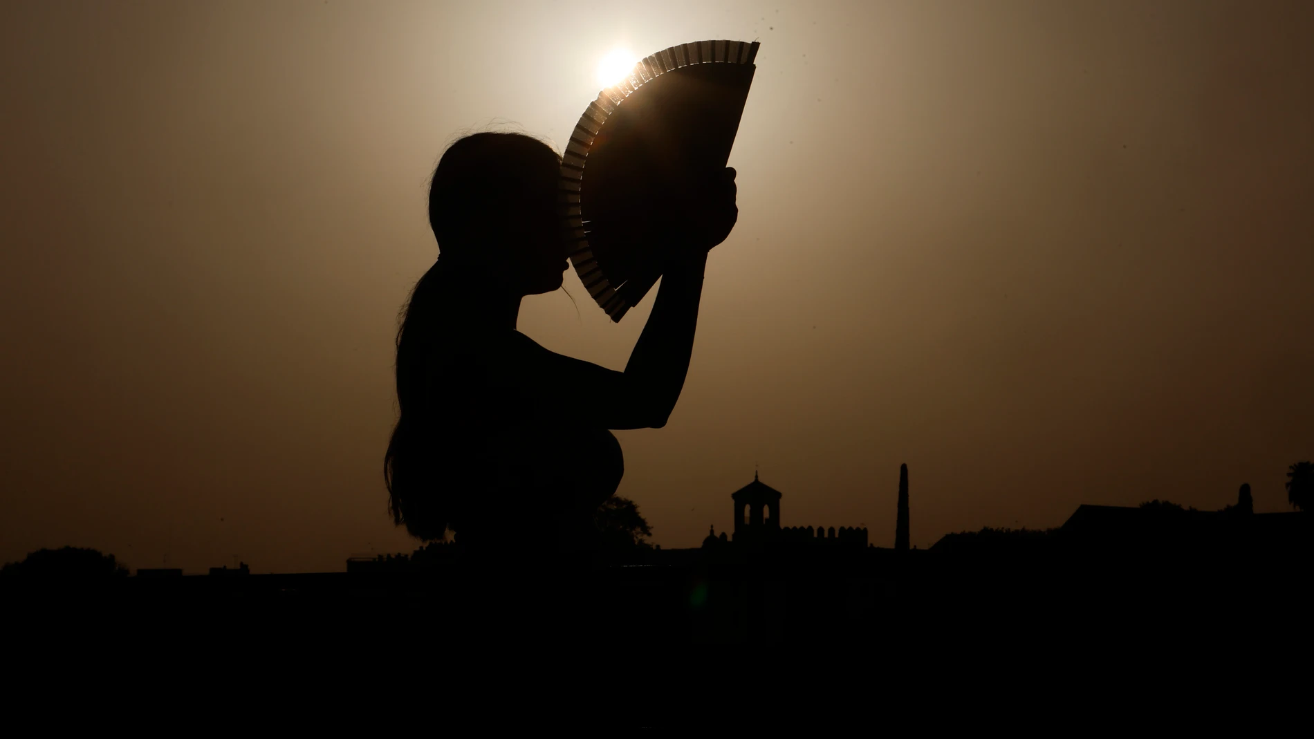 Una persona se abanica al atardecer en una jornada de altas temperaturas en la ciudad de Córdoba