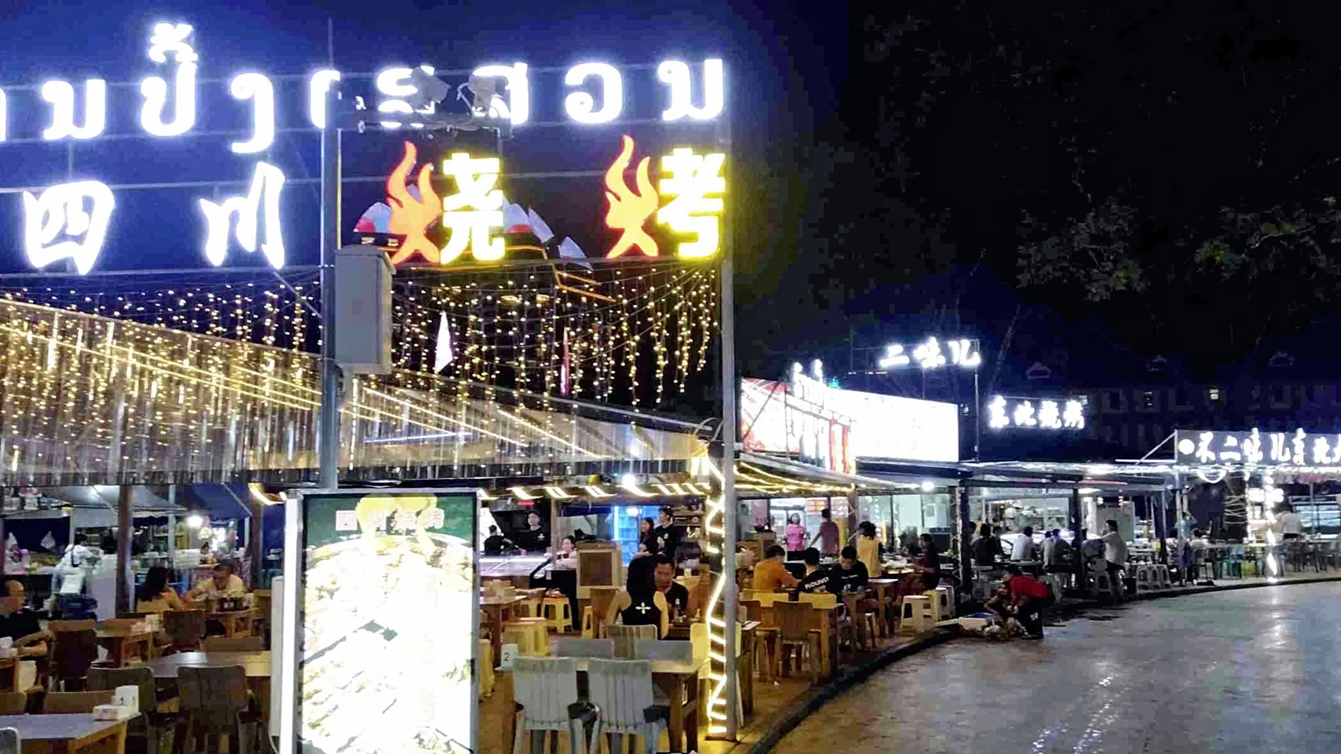 A night market is pictured at the Golden Triangle Special Economic Zone, GTSEZ, in Bokeo province, on July 28, 2024. Many sign illuminations are written in Chinese.( The Yomiuri Shimbun )