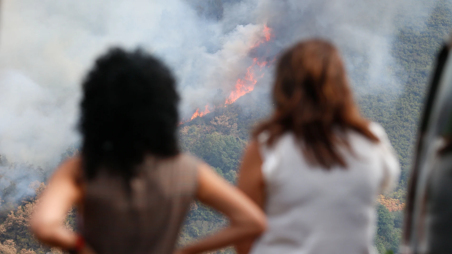 Varias personas observan el incendio, en la sierra de O Courel, a 19 de agosto de 2025, en Quiroga, Lugo, Galicia (España). El fuego amenaza la sierra de O Courel en su avance desde la localidad lucense de Quiroga lo que ha alertado a los vecinos de la zona que aún recuerdan la ola de incendios de 2022. Sin embargo, las condiciones meteorológicas son favorables y ha aumentado el número de efectivos que luchan contra el avance del incendio. 19 AGOSTO 2025;FUEGO;INCENDIO;GALICIA; Carlos Castr...