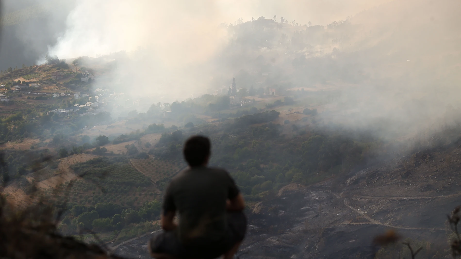 Una persona observa el incendio, en la sierra de O Courel