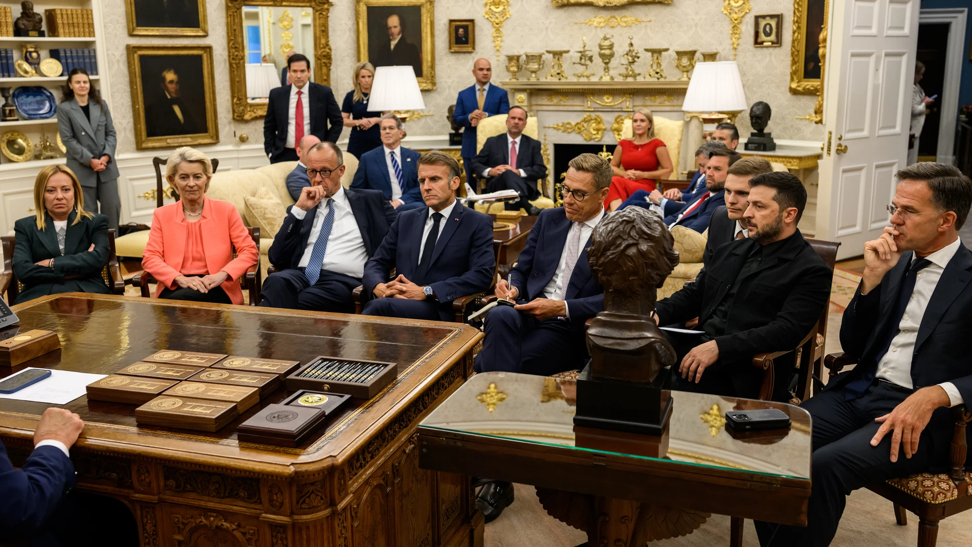 AME1541. WASHINGTON (ESTADOS UNIDOS), 19/08/2025.- Fotografía tomada de la cuenta oficial de la red social X @WhiteHouse donde se observan desde la izquierda, a la primera ministra italiana, Giorgia Meloni; la presidenta de la Comisón Europea, Ursula Von der Leyen; el canciller de Alemania, Friedrich Merz; el presidente de Francia, Emmanuel Macron; el presidente de Ucrania, Volodímir Zelenski, y el secretario general de la OTAN, Mark Rutte, reunidos con el presidente de Estados Unidos, Donal...