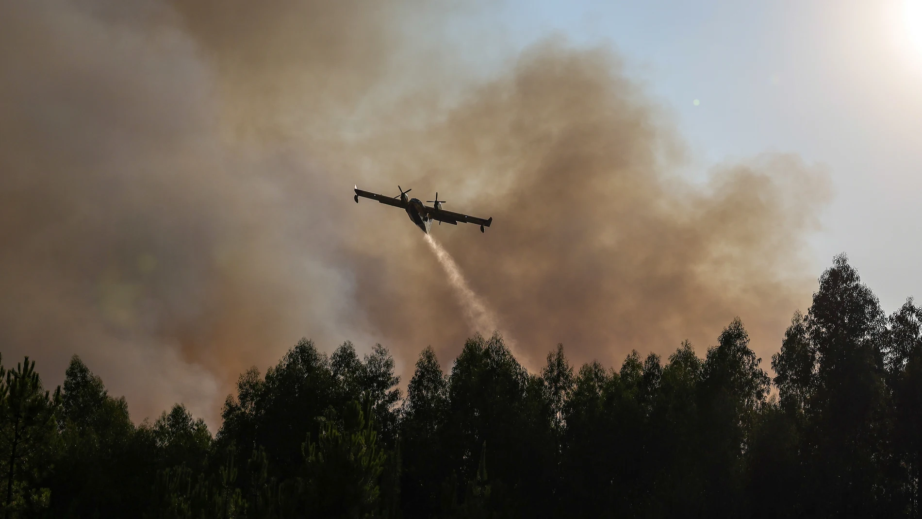 Pedrigao Grande (Portugal), 23/08/2025.- A Canadair airplane drops water during a forest fire in Pedrogao Grande, Leiria, Portugal, 23 August 2025. The two fires that are currently consuming forest in Pedrogao Grande have already reached the municipality of Serta, with various resources being deployed in both areas to combat the fire, the Civil Protection said. EFE/EPA/PAULO NOVAIS