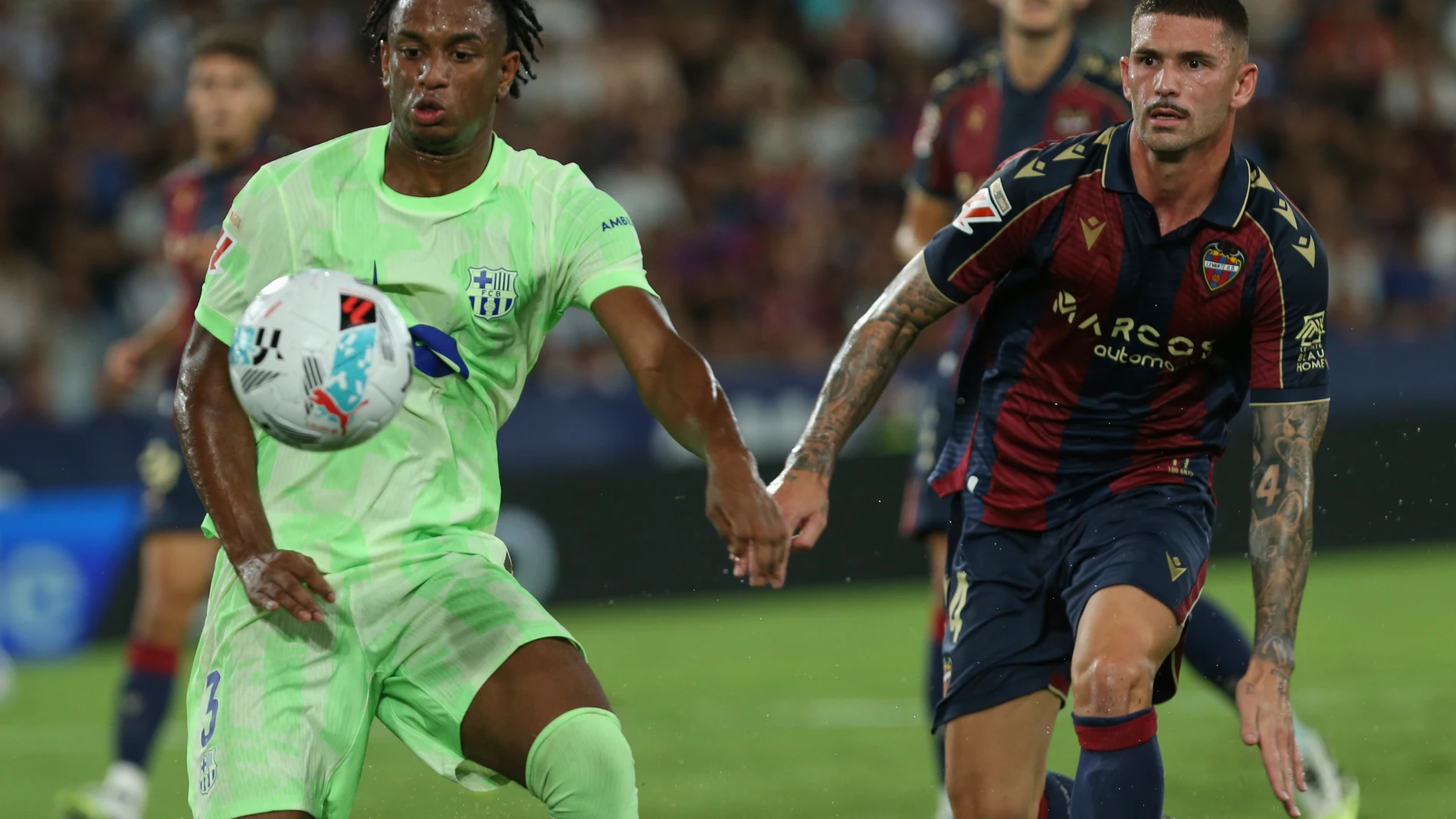 Barcelona's Alejandro Balde, left, and Levantes' Jorge Cabello fight for the ball during the La Liga soccer match between Levante and Barcelon in Valencia, Spain, Saturday, Aug. 23, 2025. ((AP Photo/Alberto Saiz)