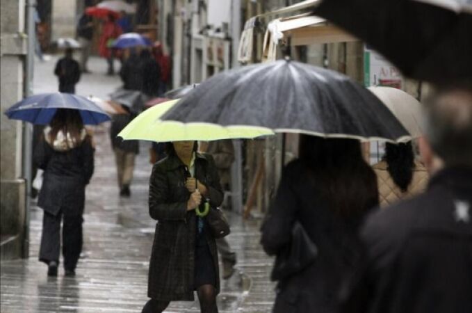  Varias personas se protegen de la lluvia con paraguas