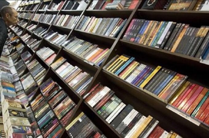 Un hombre ojea varios libros en una librería