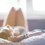 Una mujer tumbada sobre una cama