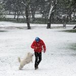 Un hombre pasea con su perro por el parque Emperatriz María de Austria, en Carabanchel,