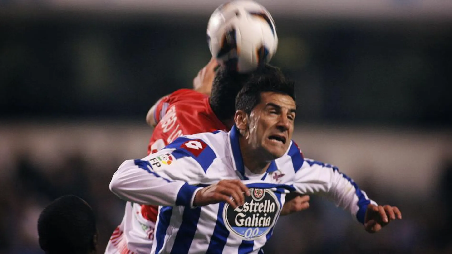 El jugador del Deportivo de La Coruña, Iván Sánchez Rico "Riki"(d), disputa un balón con el jugador del Granada Club de Fútbol, Íñigo López (detrás)