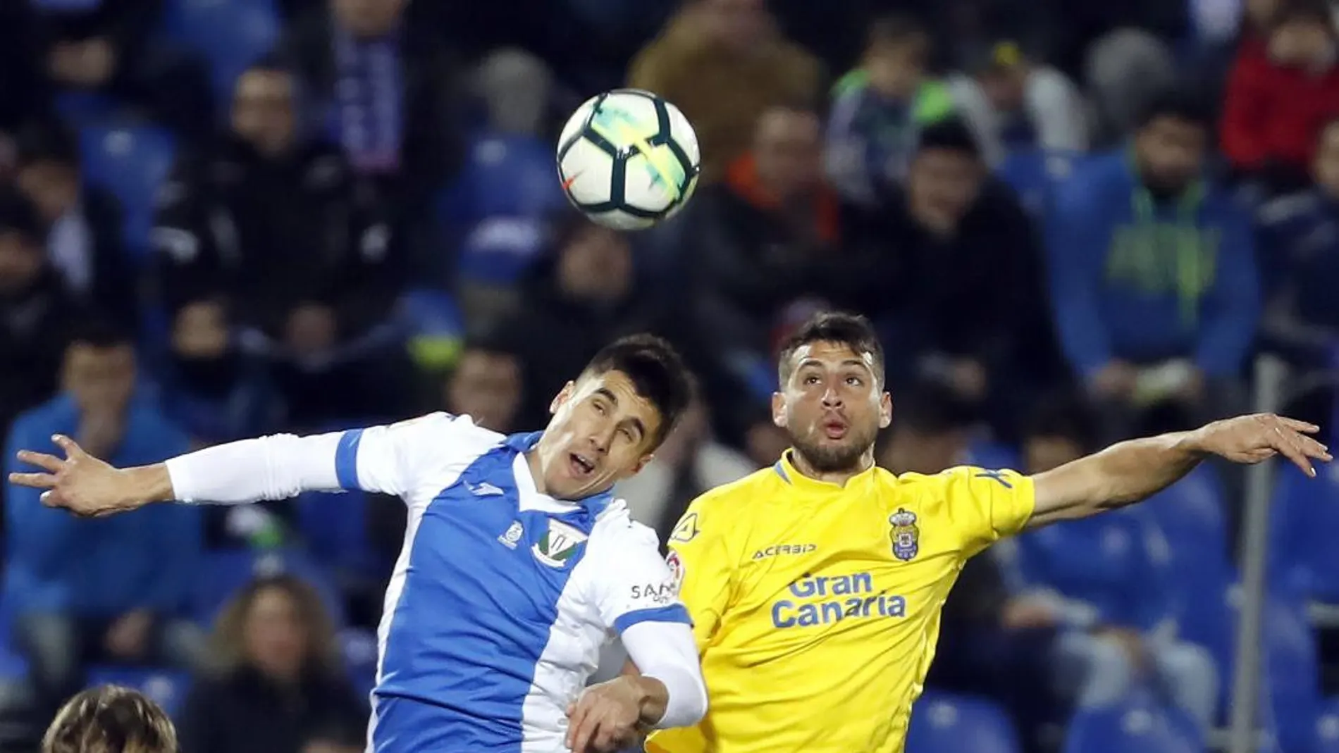 El centrocampista del Leganés Rubén Pérez cabecea un balón ante el argentino Jonathan Calleri, de la UD Las Palmas