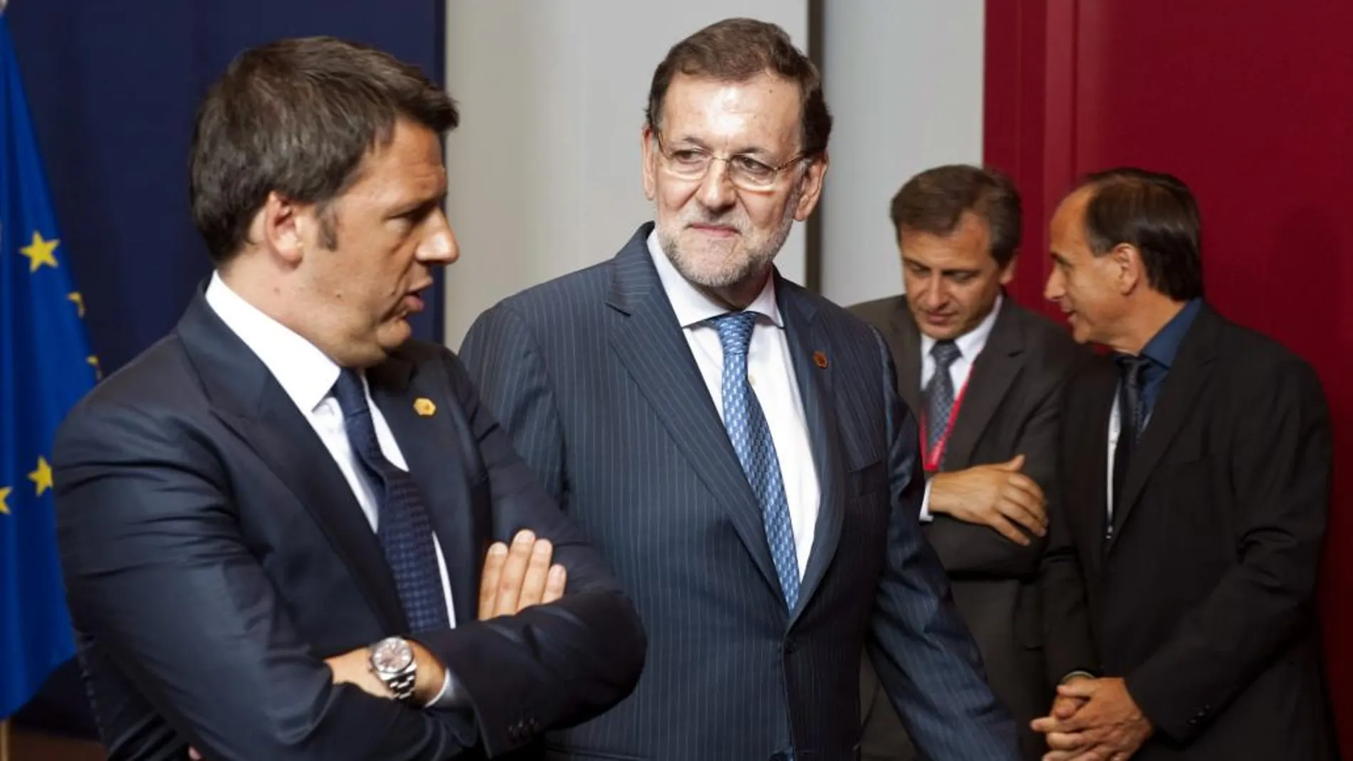 El presidente del Gobierno español, Mariano Rajoy (d), conversa con el primer ministro italiano, Matteo Renzi (i) momentos antes de la foto de familia de los líderes europeos