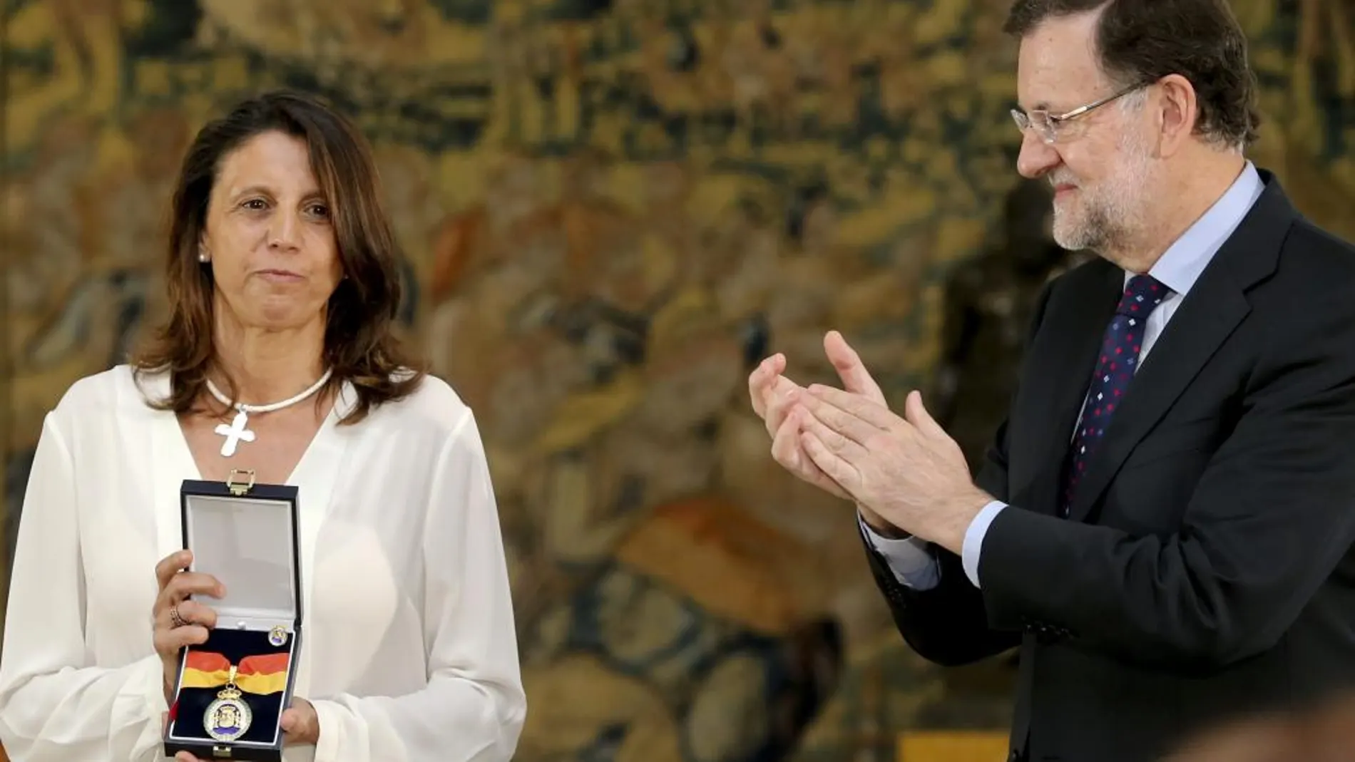 El presidente del Gobierno, Mariano Rajoy, aplaude a una de las hijas de la fundadora de la Asociación de Víctimas del Terrorismo (AVT), tras hacer entrega hoy de la Medalla de la Orden del Mérito Constitucional concedida a título póstumo a su madre.