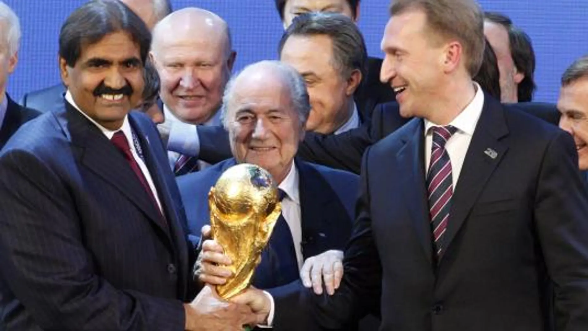 El jeque Al Thani, director de la candidatura de Qatar, Blatter y Shuvalev, viceprimer ministro ruso, sujetan la Copa del Mundo