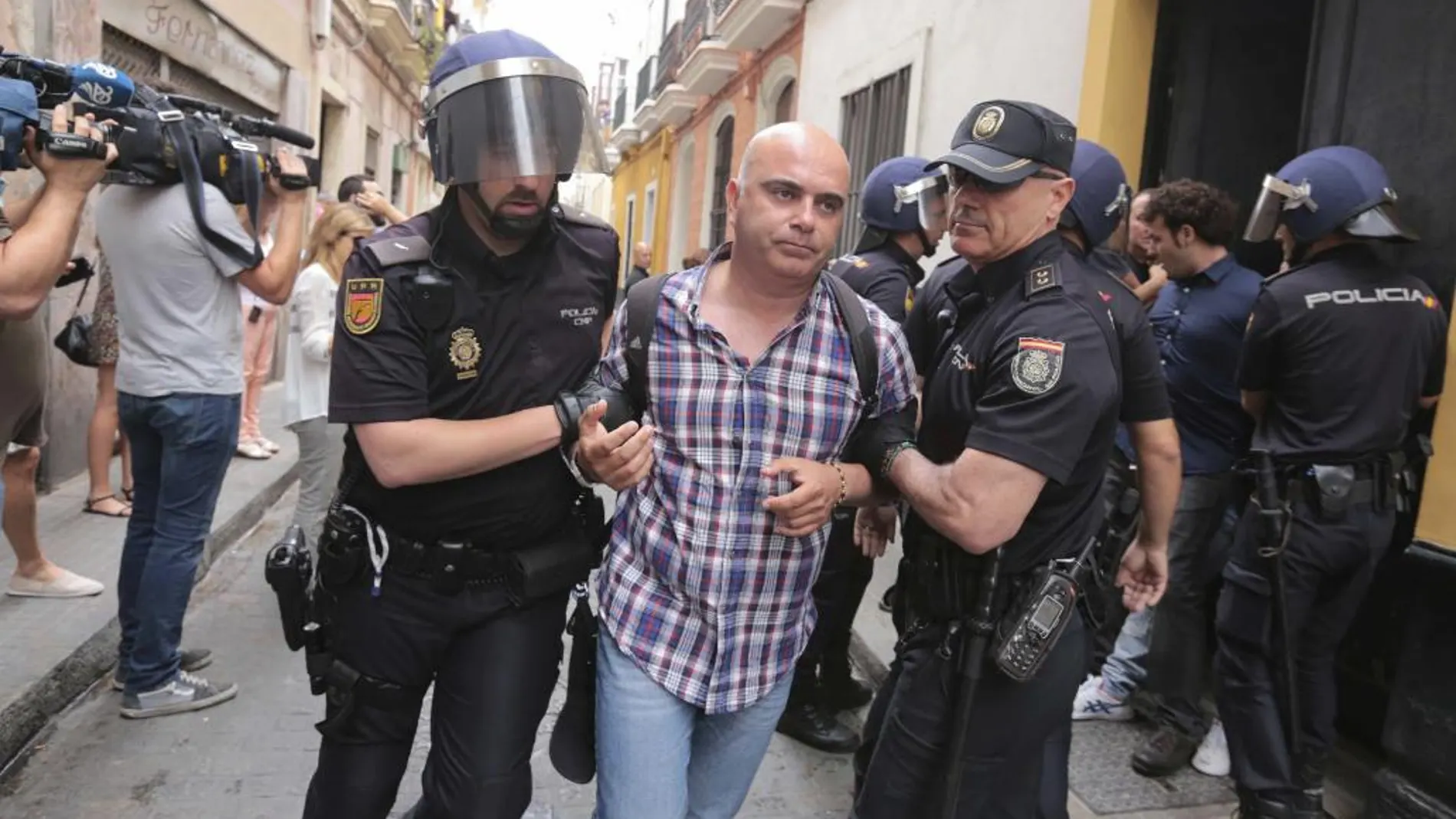 David Navarro, concejal de Por Cádiz sí se puede, es llevado por dos policías nacionales durante un desahucio