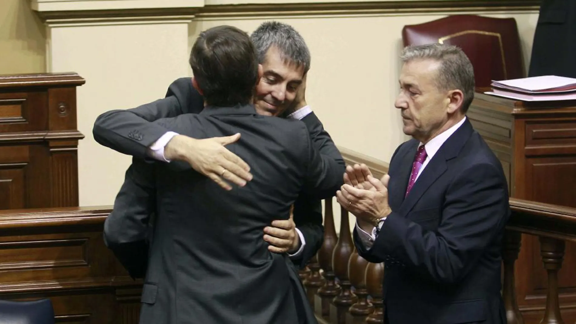 Fernando Clavijo (c) recibe la felicitación de Javier Ortiz y del presidente en funciones Paulino Rivero, tras ser proclamado presidente del Gobierno de Canarias.