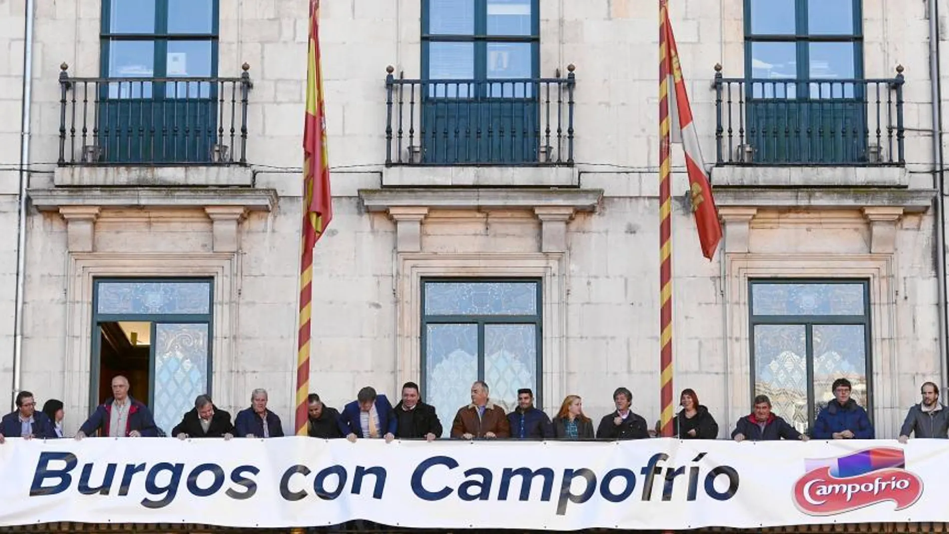 El alcalde de Burgos, Javier Lacalle, y los portavoces de los grupos municipales colocan una pancarta en el balcón del Ayuntamiento de apoyo a la reapertura de la nueva Campofrío, con motivo del segundo aniversario del incendio