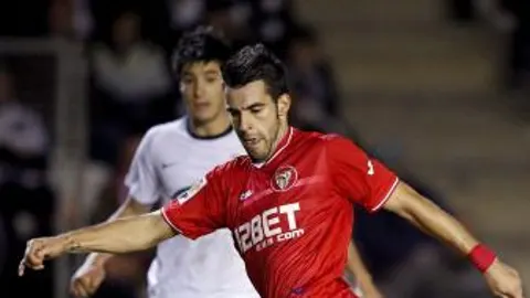 El delantero del Sevilla CF, Álvaro Negredo (d), controla el balón