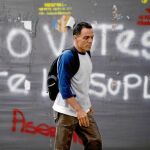 Un hombre pasa junto a una pintada que pide la abstención para las elecciones del 20 de mayo