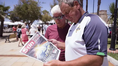 Unos británicos observan la portada del periódico "The Sun"donde se puede leer "El día de la independencia"hoy en Mijas Costa, en Málaga