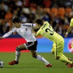 El centrocampista del Valencia CF Santiago Mina (i) intenta escaparse de Thomas Foket, defensa del KAA Gent