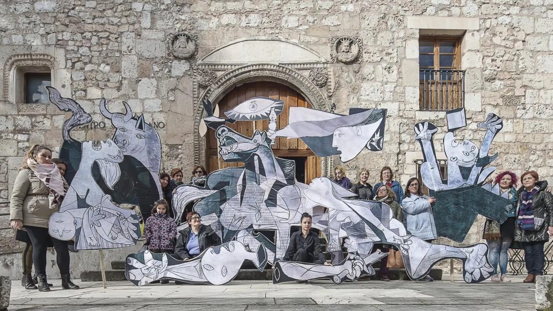 Un grupo de mujeres junto a la imagen del Guernica a las puertas de la cárcel para mujeres en Burgos