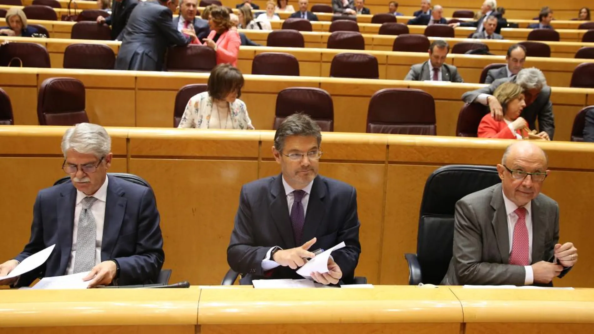 Alfonso Dastis (Exteriores), Rafael Catalá (Justicia) y Cristóbal Montoro (Hacienda), ayer, durante la sesión de control al Gobierno en el Senado