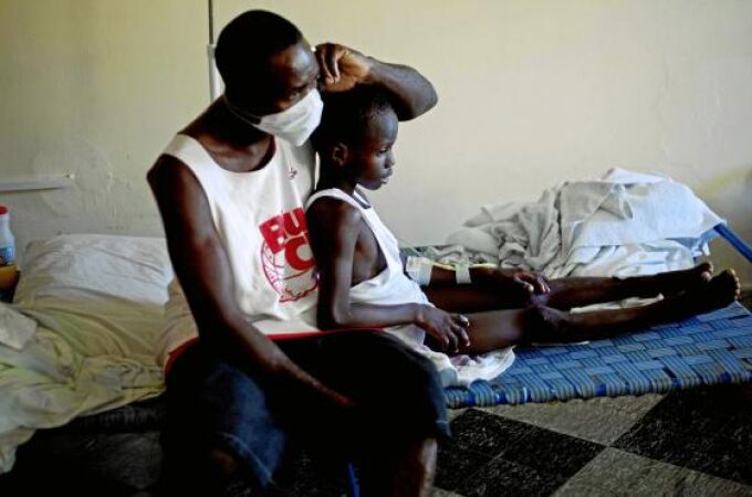 Un niño con síntomas de cólera descansa junto a un familiar en un hospital de la localidad de Archaie, en Haití