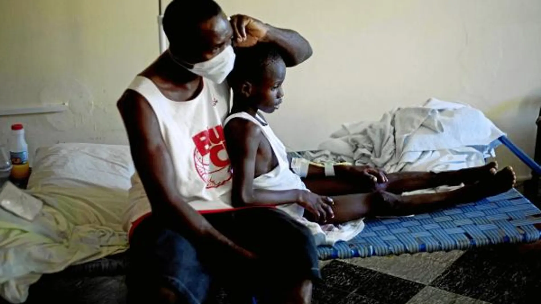 Un niño con síntomas de cólera descansa junto a un familiar en un hospital de la localidad de Archaie, en Haití