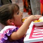 Una niña come una paella. Fuente: EFE