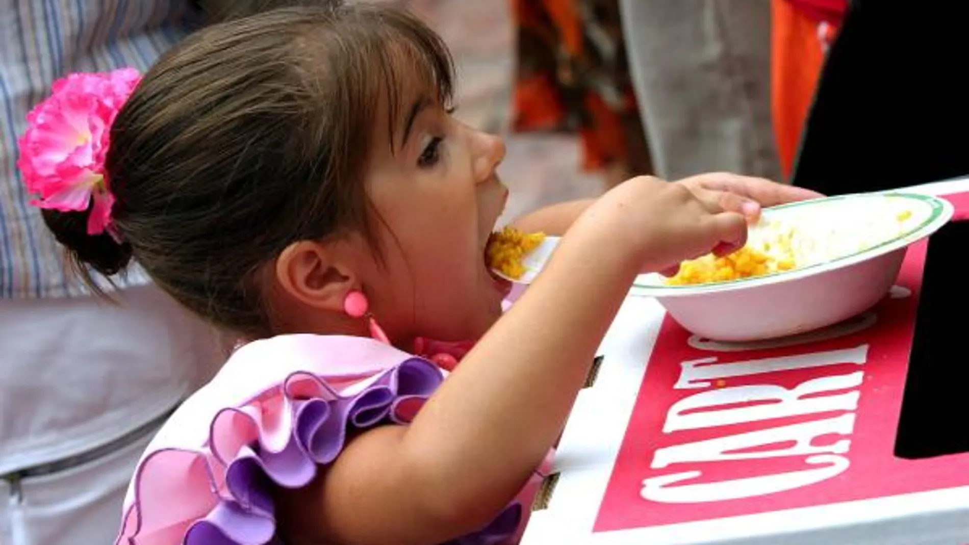Una niña come una paella. Fuente: EFE
