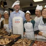 Fotografía facilitada por el PP de su presidente, Mariano Rajoy, junto a trabajadores y voluntarios del comedor social "Santiago Masarnau"a donde por tercer año consecutivo, Rajoy ha acudido como voluntario y ha ayudado a preparar y posteriormente a ser