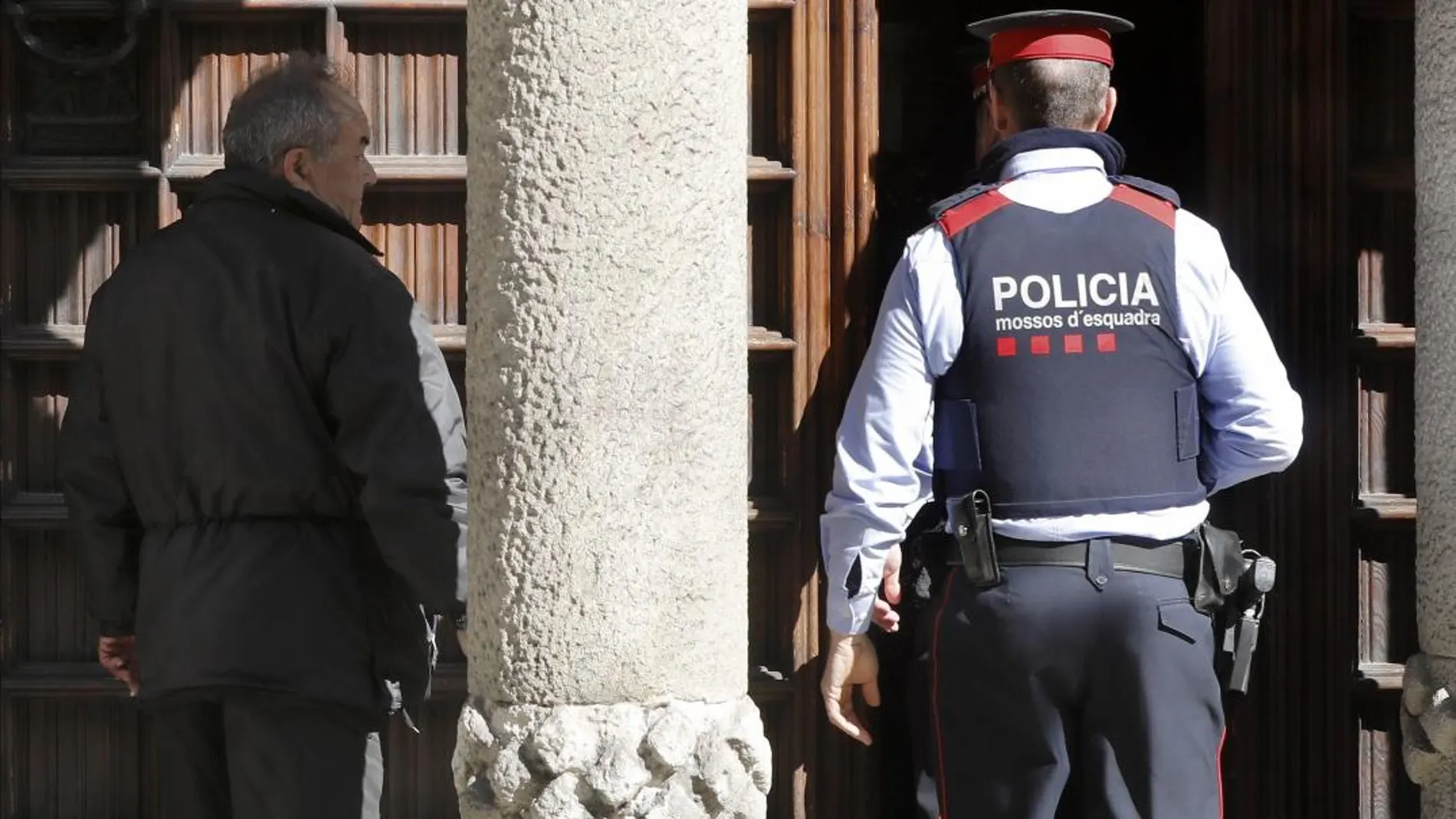 Un Mosso d'Esquadra ante la sede del Consejo de la Diplomacia Pública de Cataluña (Diplocat) que la Guardia Civil ha registrado