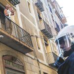 En la imagen, uno de los ocupas protestando por el desalojo en la calle San Ramón del Raval con un niño en brazos.