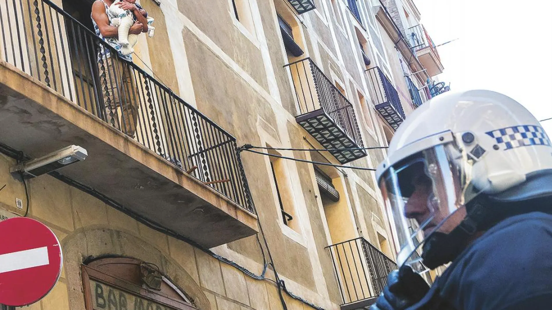 En la imagen, uno de los ocupas protestando por el desalojo en la calle San Ramón del Raval con un niño en brazos.