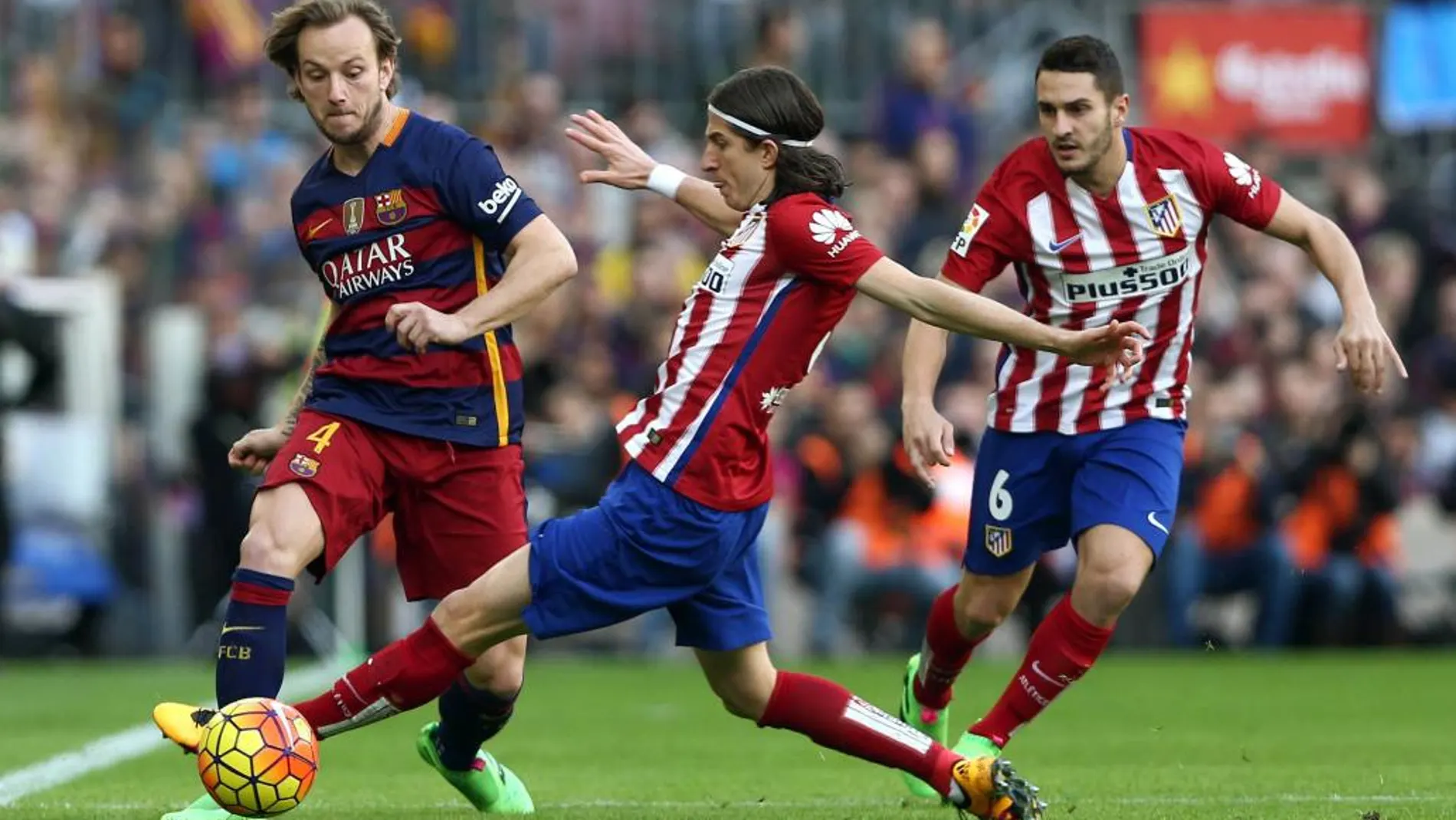 El centrocampista croata del Barcelona Ivan Rakitic pelea un balón con los jugadores del Atlético de Madrid Filipe Luis y Koke