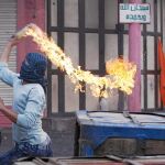 Más muertes. Un palestino oculta su rostro mientras lanza un cóctel molotov contra soldados israelíes tras la muerte de cinco árabes en Gaza y Cisjordania