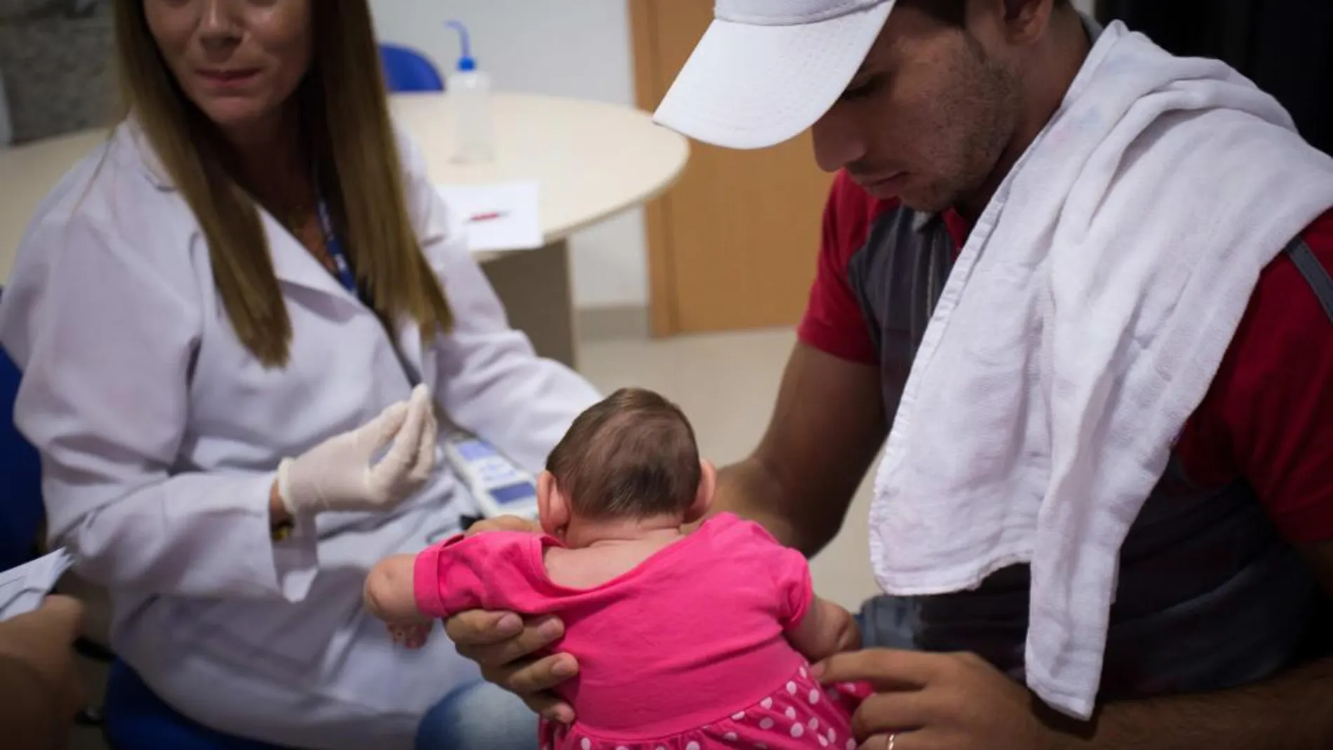 En Brasil hay cerca de 4 mil casos de microcefalia en recién nacidos que se presume están relacionados con el virus Zika. En la imagen, un padre con su hija en la consulta del médico