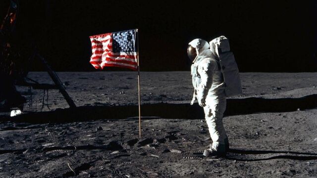 El primero en pisar la superficie lunar es Neil Armstrong y, poco después, lo hace Edwin Aldrin, mientras que Michael Collins permanece en la nave. En la foto, Aldrin posa para una fotografía junto a la bandera estadounidense, 20 de julio 1969.